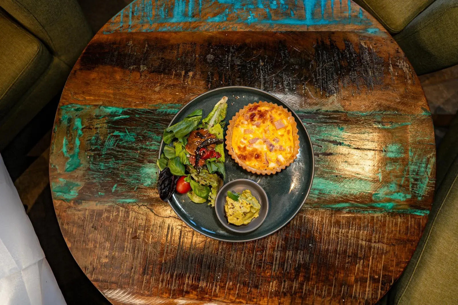 Tarta sin gluten con ensalada y dip, vista desde arriba sobre una mesa de madera.